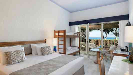 Hotelværelse med dobbeltseng, køjeseng og adgang til terrasse med havudsigt. (AI-genereret tekst)