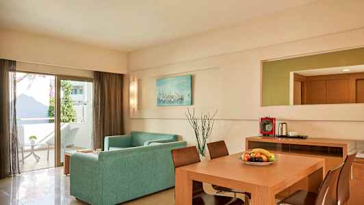 En moderne indrettet stue med en sofa, spisebord og stole. En dør fører til en balkon. (AI-genereret tekst)