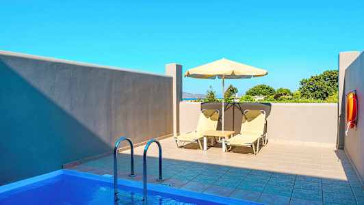 Privat udendørs pool med liggestole og parasol ved siden af. (AI-genereret tekst)