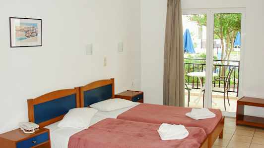 Dobbeltværelse med senge, natbord og balkon udenfor. (AI-genereret tekst)