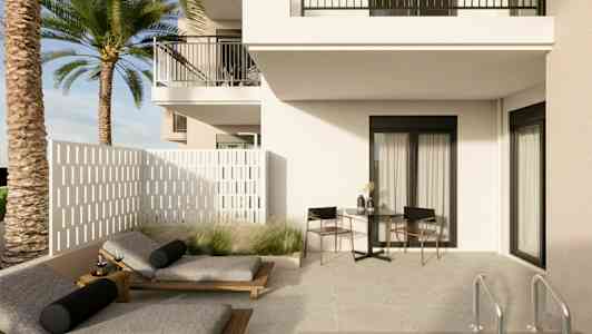 En lys terrasse med solsenge, et bord og stole ved siden af et hus samt en pool. (AI-genereret tekst)