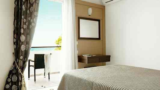 Hotelværelse med seng, spejl, gardiner og altan med havudsigt. (AI-genereret tekst)