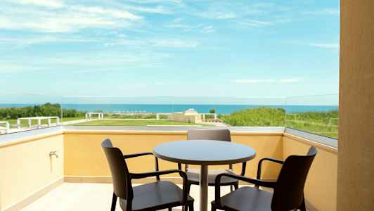 Altan med bord og stole med udsigt over havet. (AI-genereret tekst)