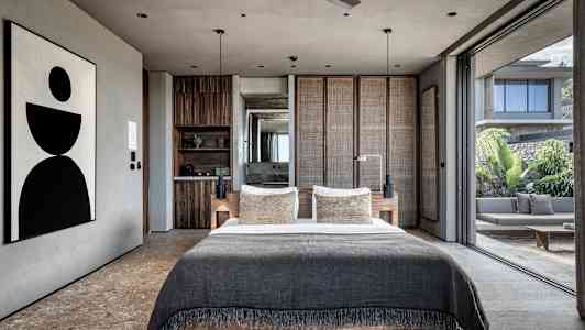 Moderne soveværelse med stor seng og åben glasfacade der vender ud mod terrasse. (AI-genereret tekst)