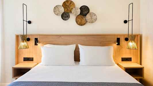 Seng med to puder og dekorationer på væggen. (AI-genereret tekst)