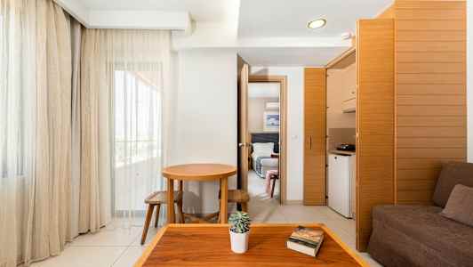 Et hotelværelse med enkel indretning, mørke møbler og store vinduer. (AI-genereret tekst)