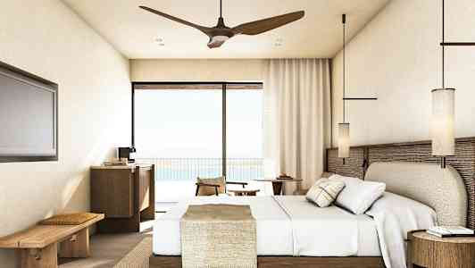 Et hotelværelse med en seng, møbler og altandør med udsigt. (AI-genereret tekst)