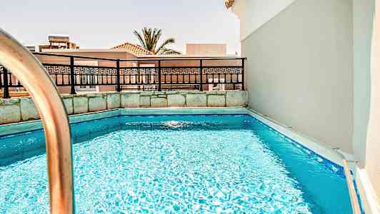 Billede af en lille pool med et rækværk og bygninger i baggrunden. (AI-genereret tekst)