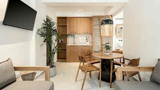 Moderne stue med trægulvmøbler, et rundt spisebord og en plante. (AI-genereret tekst)