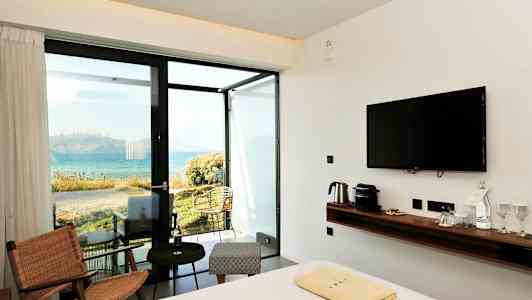 Et hotelværelse med moderne interiør og udsigt over havet. (AI-genereret tekst)