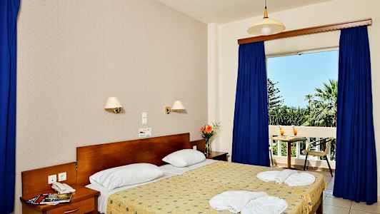 Interiør af et soveværelse med en dobbeltseng, natbord og udsigt til en balkon. (AI-genereret tekst)