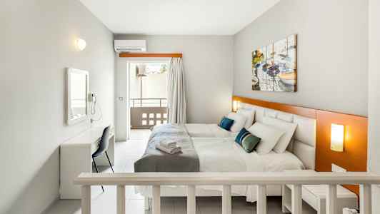 Værelse med to senge, et skrivebord og en altan. (AI-genereret tekst)