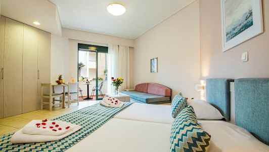 Hotelværelse med to senge, siddeområde og udgang til altan. (AI-genereret tekst)