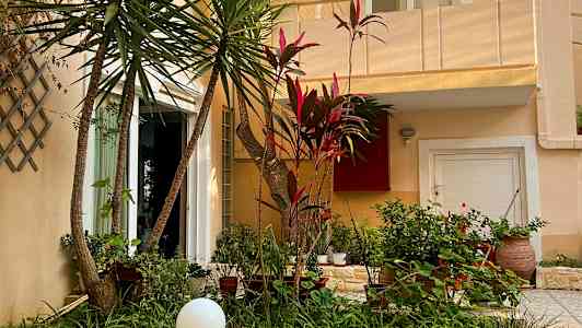 Udvendigt af et hus med frodigt haveområde foran. (AI-genereret tekst)