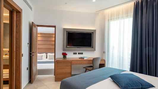 Et hotelværelse med moderne indretning, en seng, et skrivebord og et fjernsyn. (AI-genereret tekst)