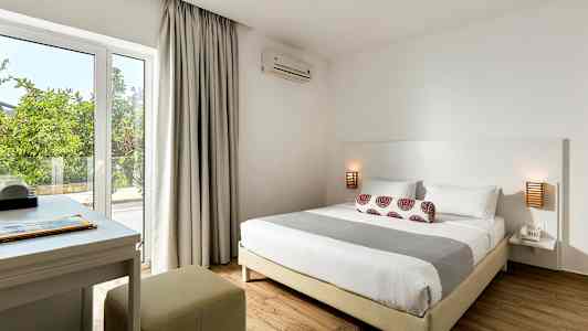 Et soveværelse med en dobbeltseng, natbord og skrivebord tæt på vinduet. (AI-genereret tekst)