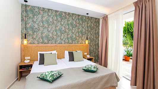 Soveværelse med dobbeltseng, grønne puder og dekoreret væg. (AI-genereret tekst)