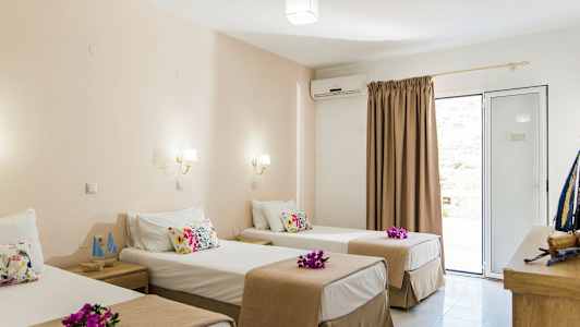 Hotelværelse med tre enkeltsenge, dekoreret med blomster. (AI-genereret tekst)