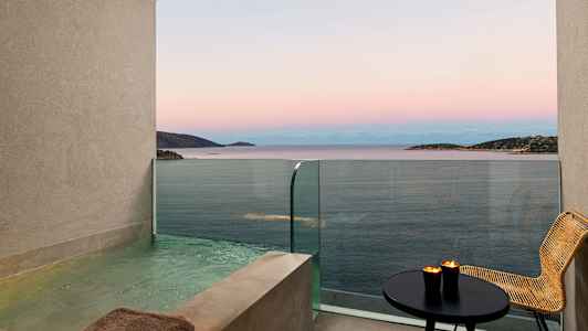 Udsigt over havet fra en balkon med en privat pool, bord og stol. (AI-genereret tekst)