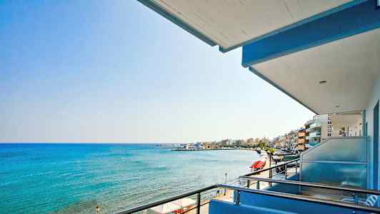 Udsigt fra en balkon over havet og en strandpromenade. (AI-genereret tekst)