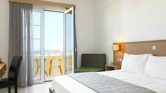 Et hotelværelse med en dobbeltseng og en balkon med udsigt. (AI-genereret tekst)