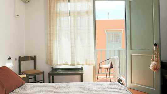 Et soveværelse med åben dør til en altan. (AI-genereret tekst)