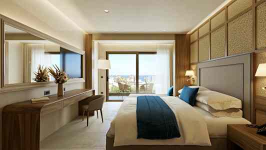 Et hotelværelse med en stor seng og vinduer, der åbner ud til en balkon med udsigt. (AI-genereret tekst)