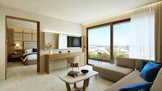 Et moderne hotelværelse med opholdsstue, separat soveværelse og udsigt til havet gennem store vinduer. (AI-genereret tekst)