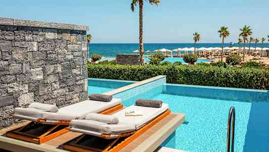 Liggestole ved en privat pool med havudsigt. (AI-genereret tekst)