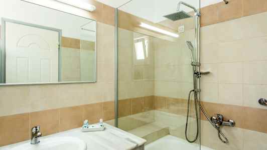 Et badeværelse med bruser og håndvask. (AI-genereret tekst)