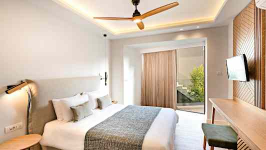 Et moderne soveværelse med en stor seng, et skrivebord og et fjernsyn. (AI-genereret tekst)