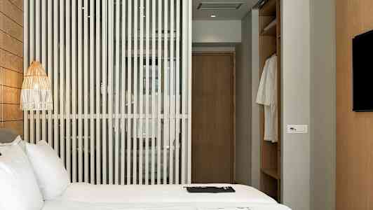 Hotelværelse med en seng, en trævæg og et garderobeskab. (AI-genereret tekst)