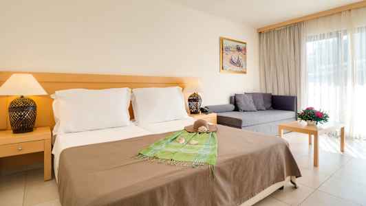 Hotelværelse med dobbeltseng, sofa og bord. (AI-genereret tekst)