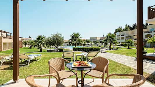 En siddegruppe med udsigt over en frodig have og en pool. (AI-genereret tekst)