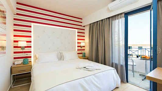 Et hotelværelse med en seng, natbord og åben balkondør. (AI-genereret tekst)