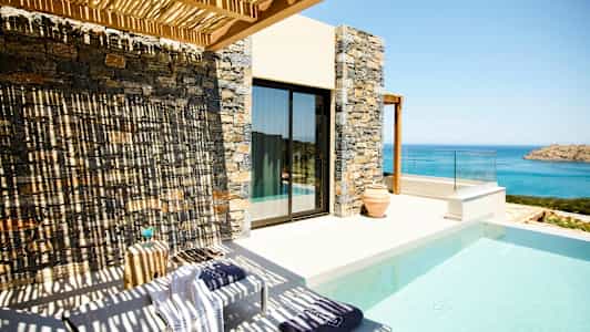 Terrasse med pool og udsigt over havet. (AI-genereret tekst)