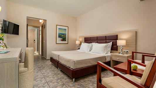 Et hotelværelse med en dobbeltseng, en lænestol og et bord. (AI-genereret tekst)