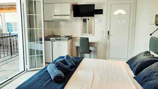 Et hotelværelse med en seng, et lille køkkenområde og en altan. (AI-genereret tekst)