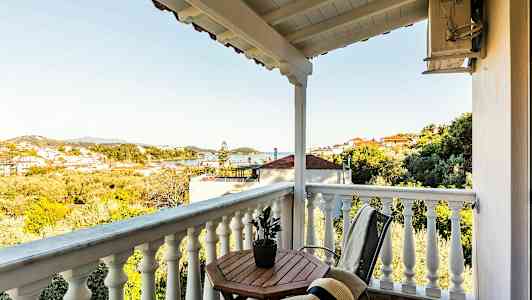 En altan med udsigt over et landskab med huse og træer. (AI-genereret tekst)