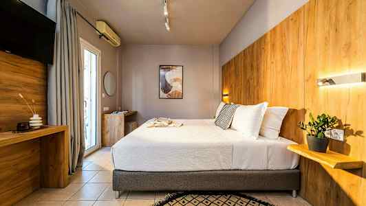 Et moderne hotelværelse med en stor seng, træpaneler på væggen og en plante på en hylde. (AI-genereret tekst)