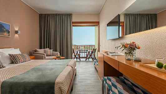 Et hotelværelse med dobbeltseng og balkonudsigt over landskab. (AI-genereret tekst)