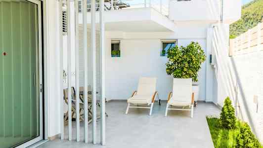 Billede af en terrasse med liggestole og beplantning. (AI-genereret tekst)