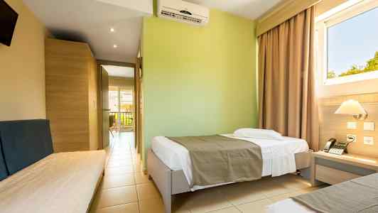 Et hotelværelse med enkeltsenge og udsigt gennem vinduet. (AI-genereret tekst)