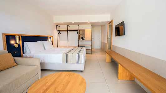 Et moderne hotelværelse med en dobbeltseng, sofa og træinteriør. (AI-genereret tekst)