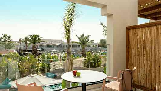 Udsigt fra en terrasse med bord, stole og dekorativ beplantning. (AI-genereret tekst)