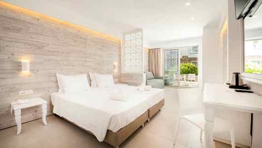 Moderne hotelværelse med dobbeltseng, siddeområde og balkon. (AI-genereret tekst)