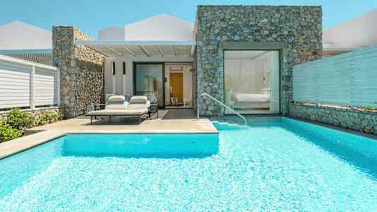 En villa med pool og liggestole ved indgangen. (AI-genereret tekst)