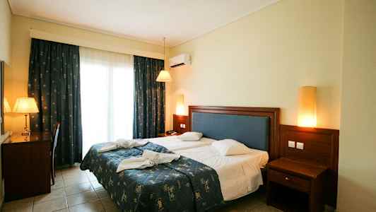 Billede af et hotelværelse med en dobbeltseng, skrivebord og natbord. (AI-genereret tekst)