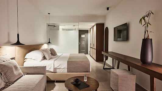 Et moderne hotelværelse med dobbeltseng, sofa og elegant indretning. (AI-genereret tekst)