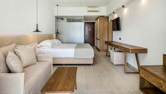 Et hotelværelse med en seng, en sofa og trêmøbler. (AI-genereret tekst)